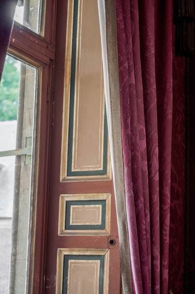 White wooden frame window near the red curtains
